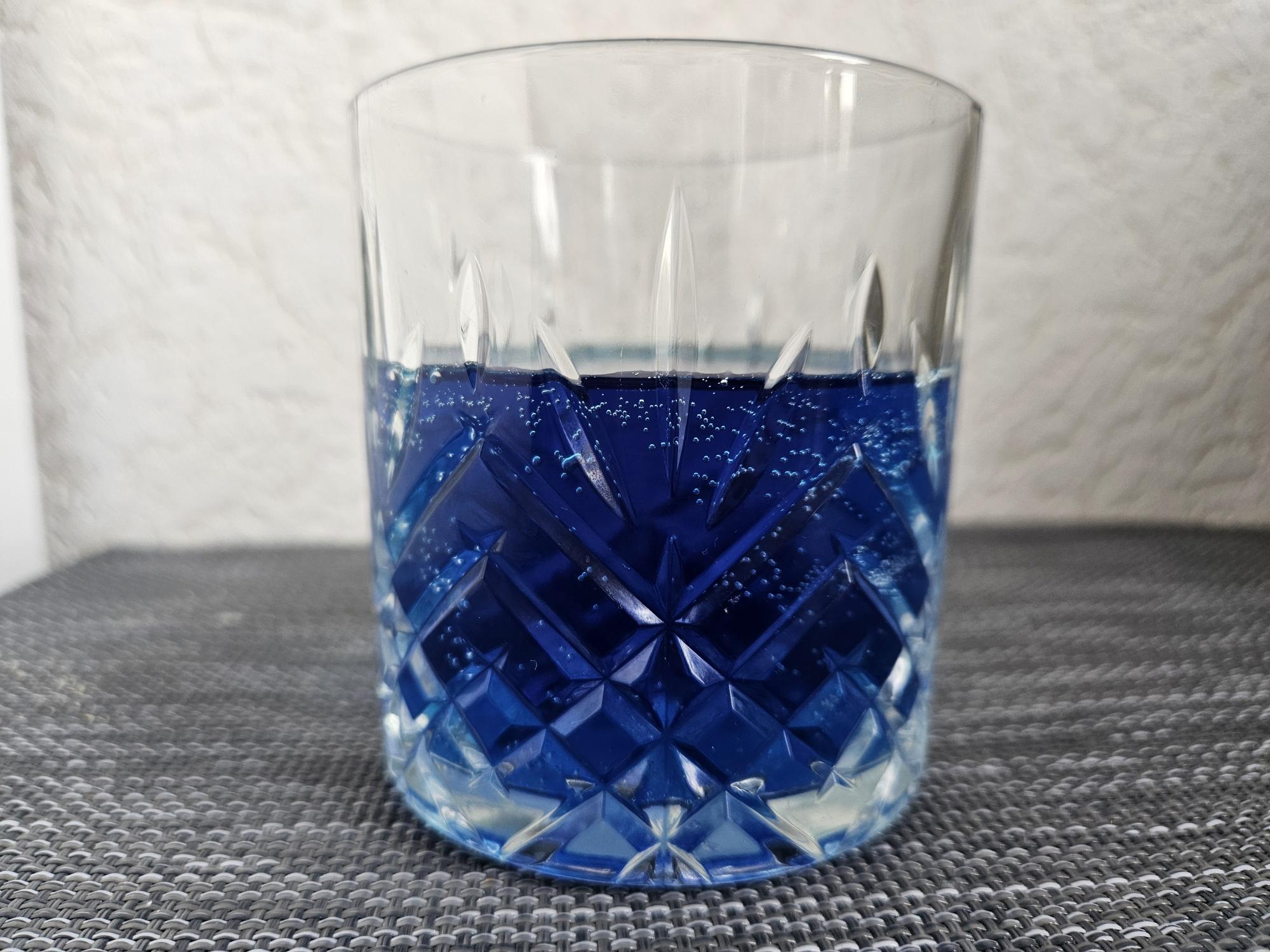 een glas blauwe cola